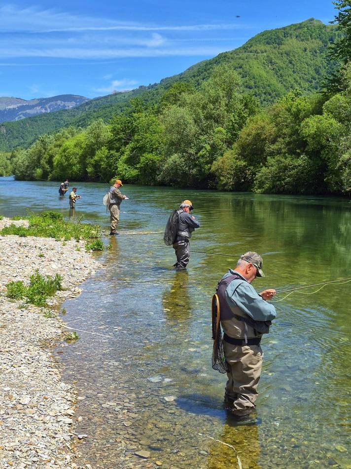 Anglers fishing in a clear mountain river