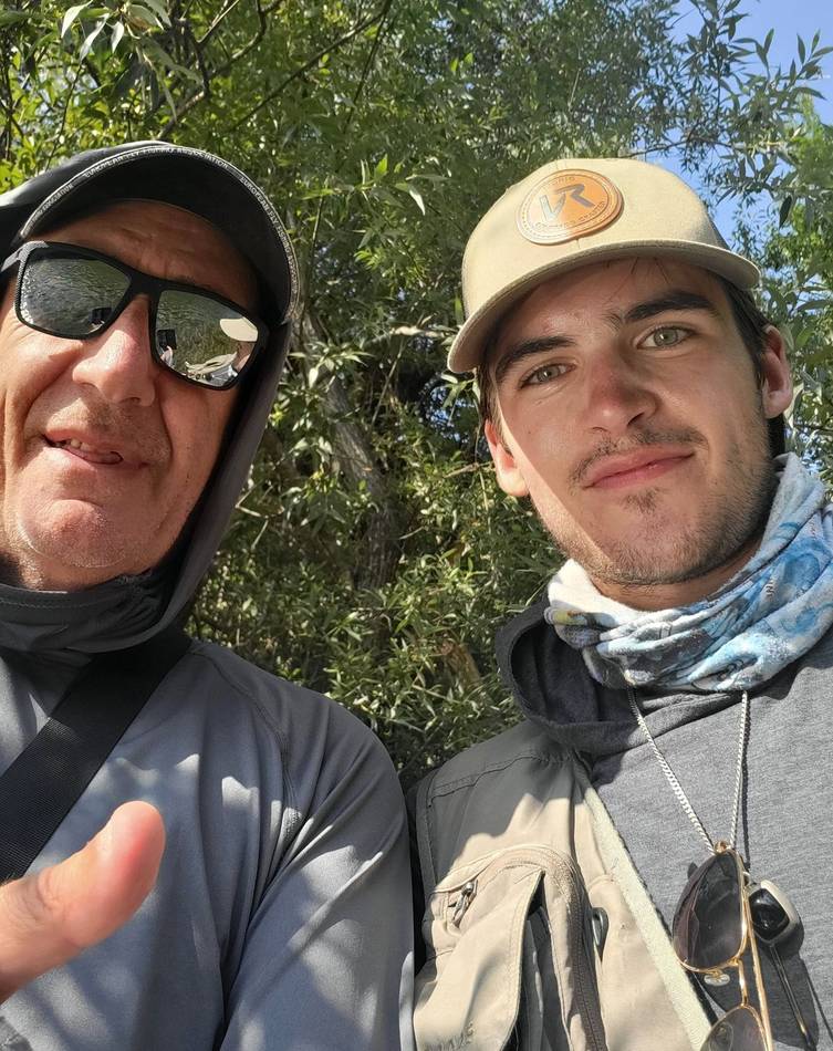 A guide and a young angler on the riverbank