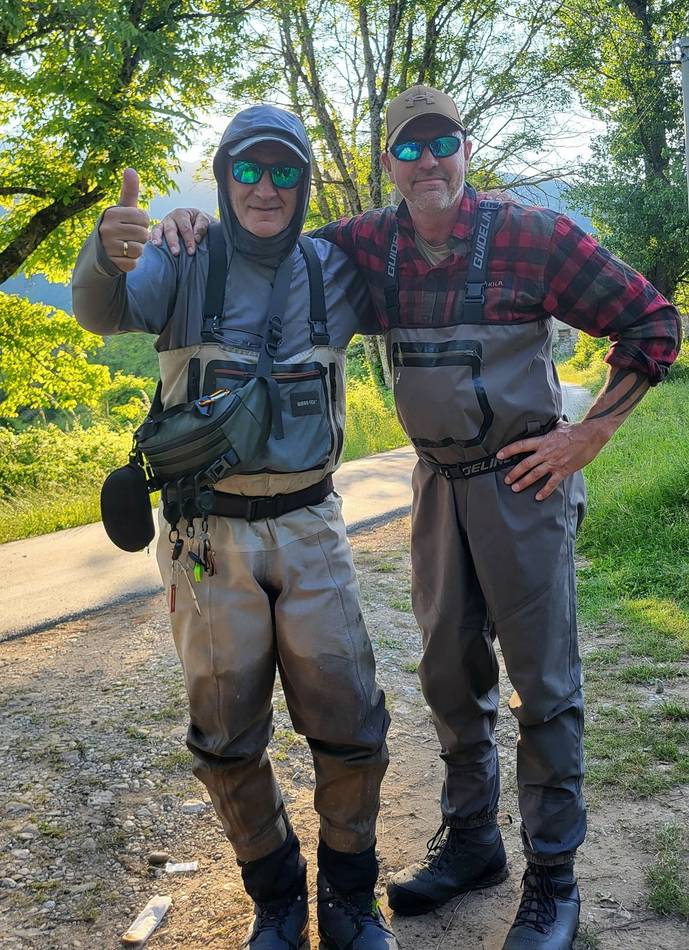 Two anglers on a country road, thumbs up