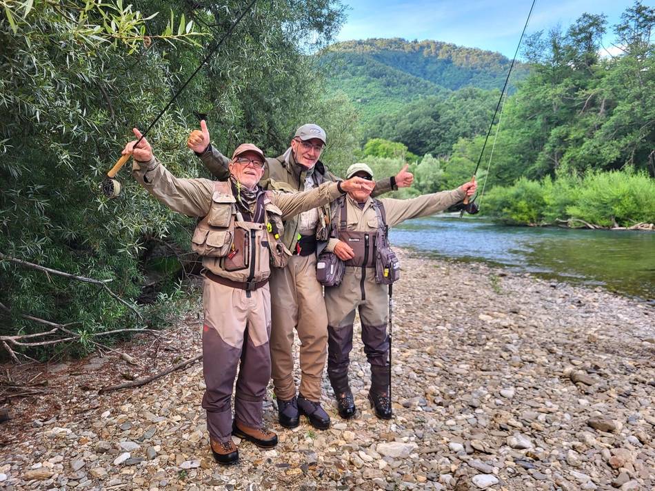 Three anglers on the gravel bank with arms wide open