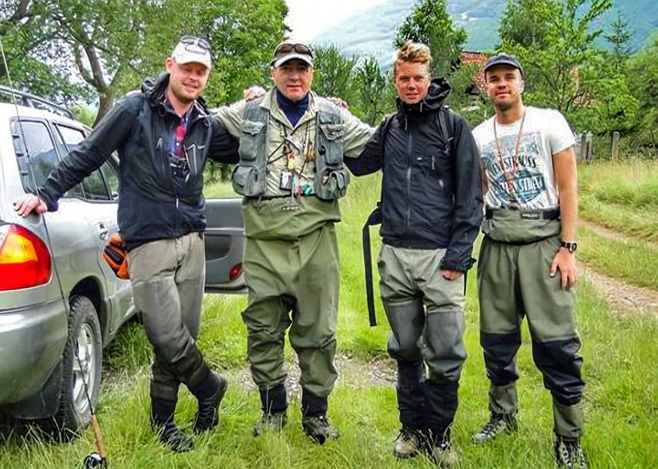 Four anglers standing by a car