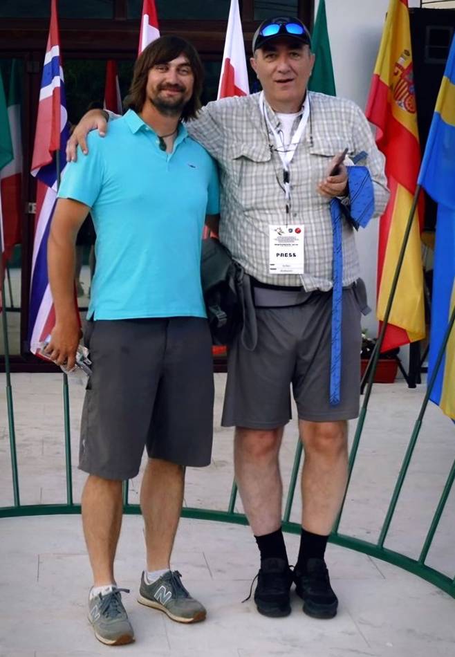 Two friends posing in front of international flags