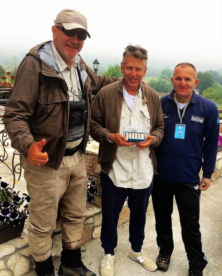 Three anglers with a box of flies