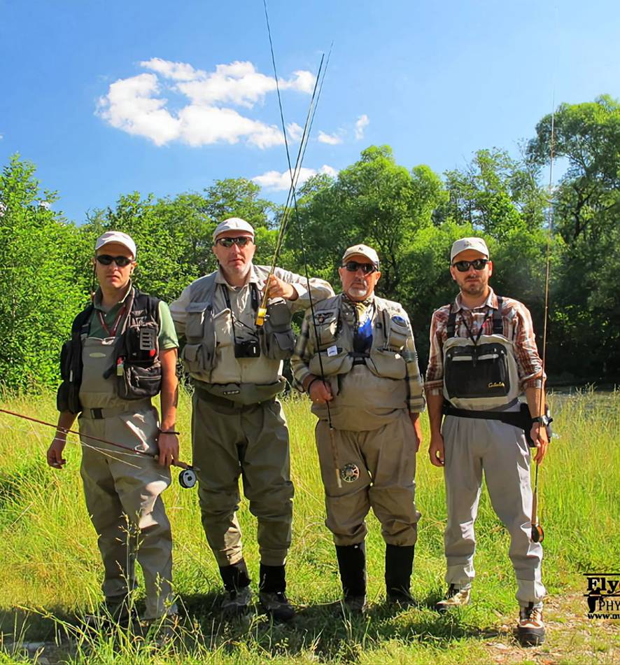 Four anglers lined up on the grass with their rods
