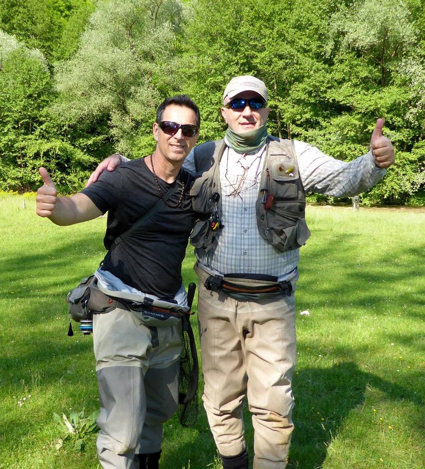 Two anglers giving thumbs up in a green meadow