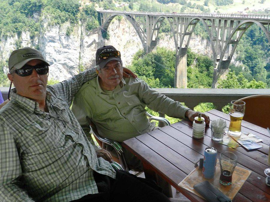 Two anglers relaxing on a terrace with the canyon bridge behind them
