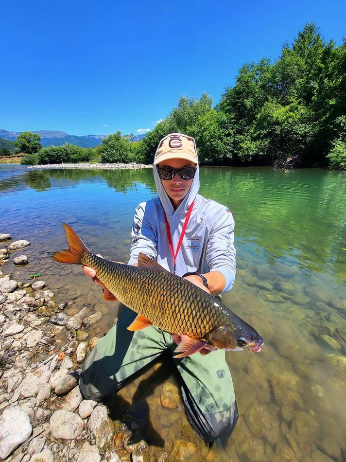 A guest with a golden chub caught on the river