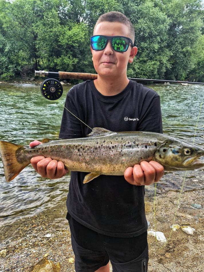 A guest smiling with his grayling catch