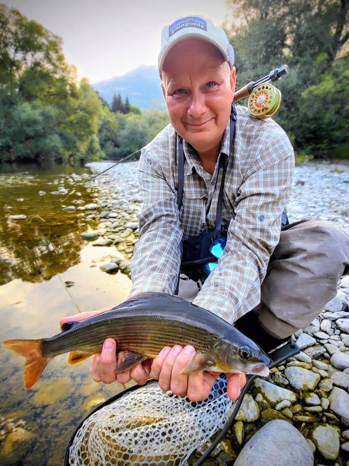A guest with his grayling catch and landing net at dusk